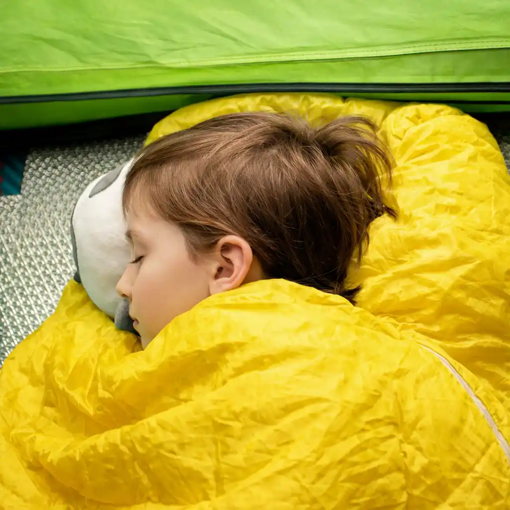 Girl sleeping in a yellow sleeping bag inside a lime green tent.