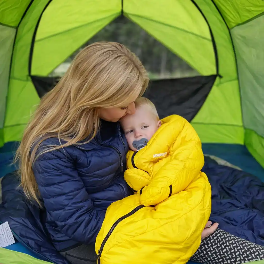 Kids sleeping bags set up inside a family camping tent at night