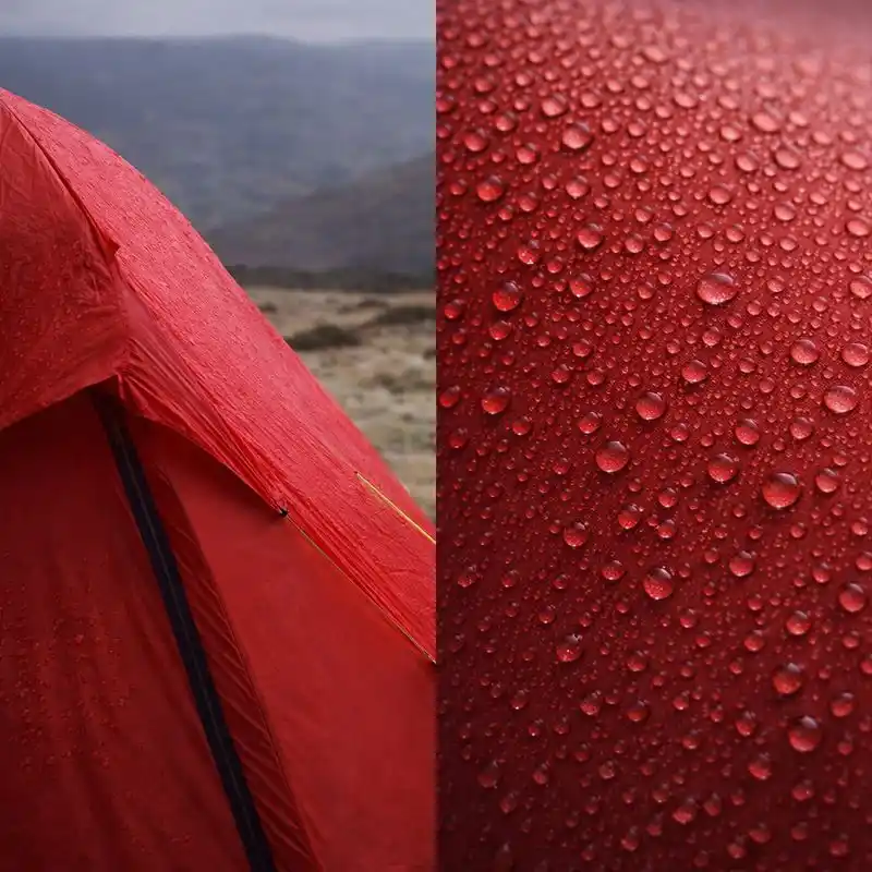 Red camping tent at night with visible condensation droplets on the fabric, showing moisture buildup on the tent surface in calm weather.