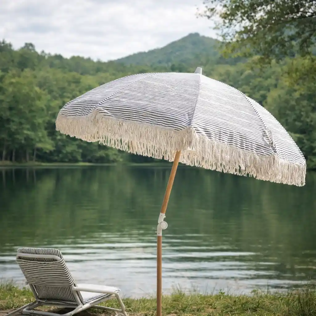 camping umbrella providing shade by a forest lake with chair and peaceful outdoor setting