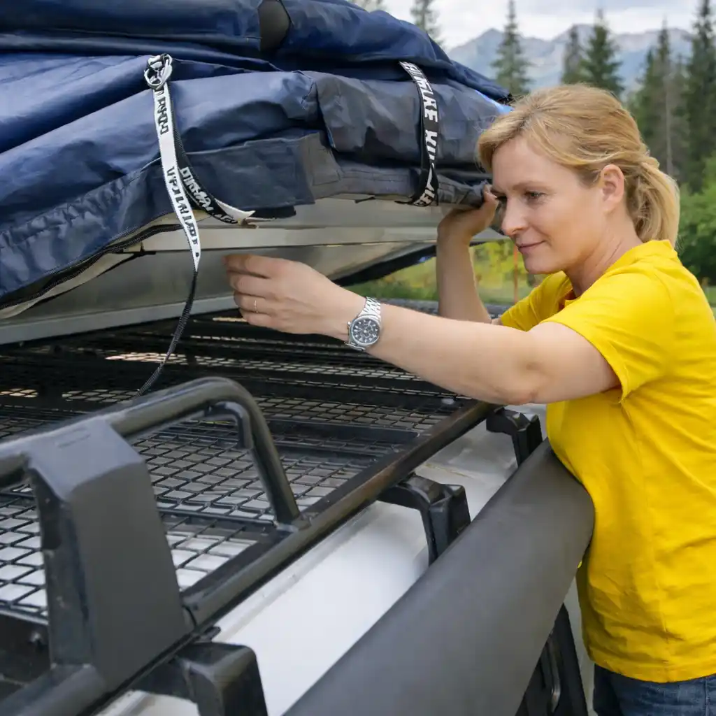 Woman installing a rooftop tent on SUV roof rack showing step-by-step mounting process