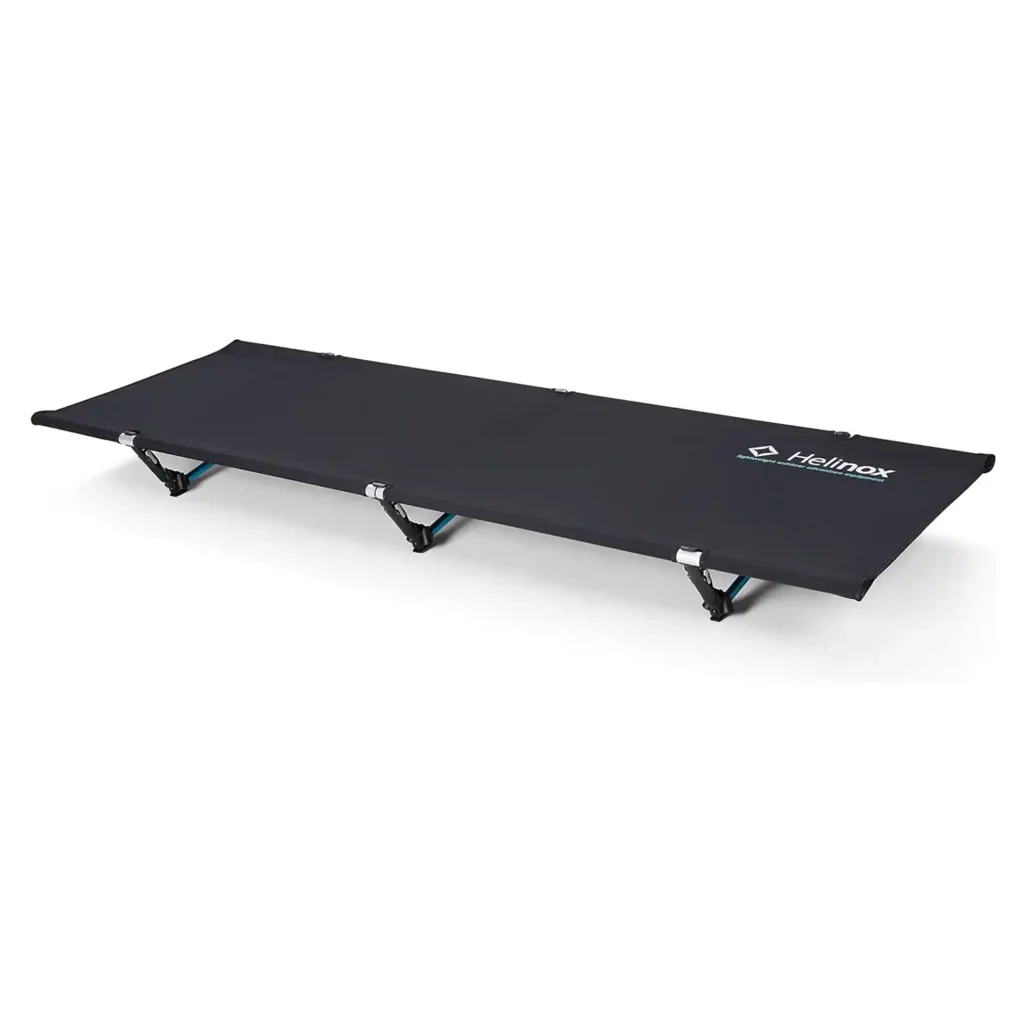 Helinox Cot One Convertible lightweight premium camping cot set up at a scenic campsite for comfortable back support.