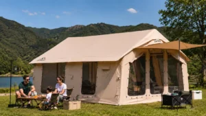 Large inflatable camping tent at a sunny lakeside campsite during hot summer weather with a family relaxing outside, showcasing excellent ventilation and comfortable warm-weather camping.