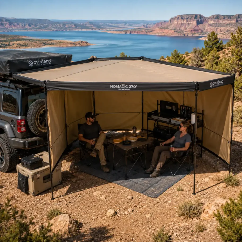 Overland Vehicle Systems Nomadic 270 HD Awning creating a spacious shaded campsite beside an SUV during an overlanding adventure.
